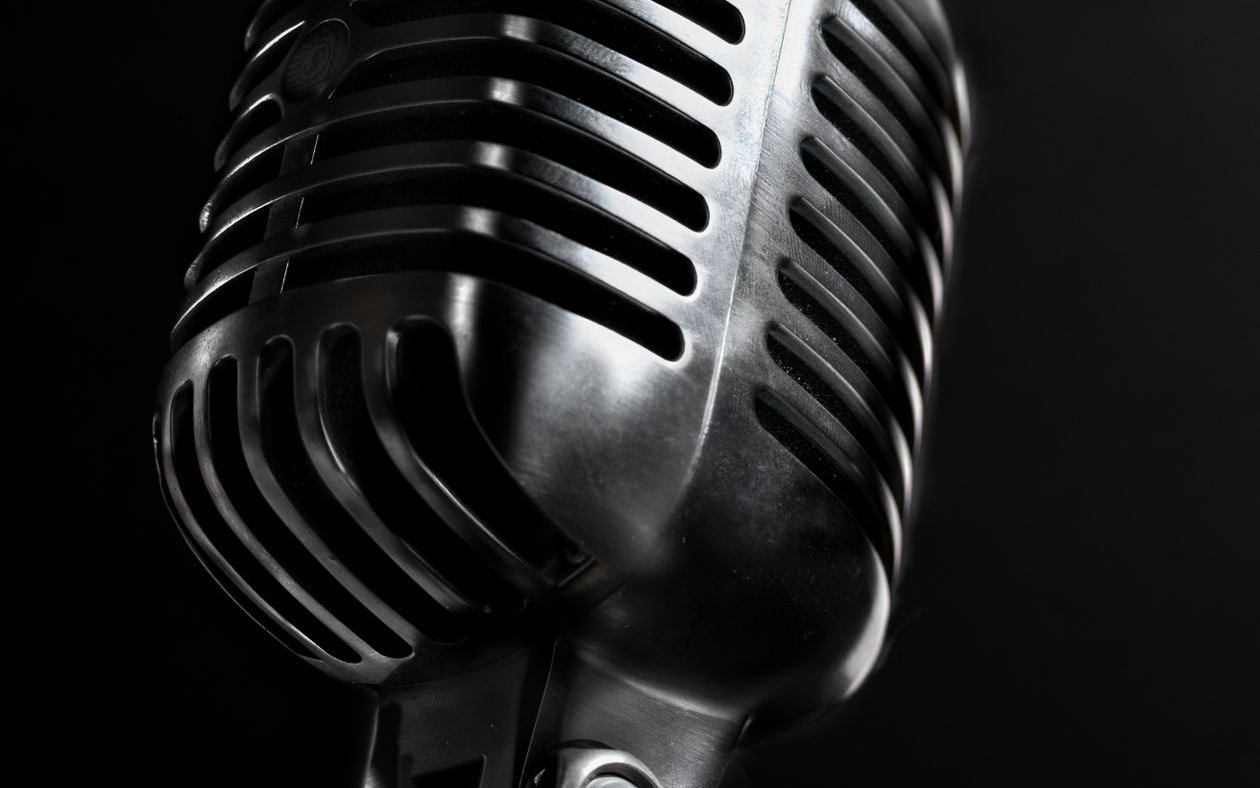 Vintage chrome studio microphone on black — Shark Bite Biz podcast