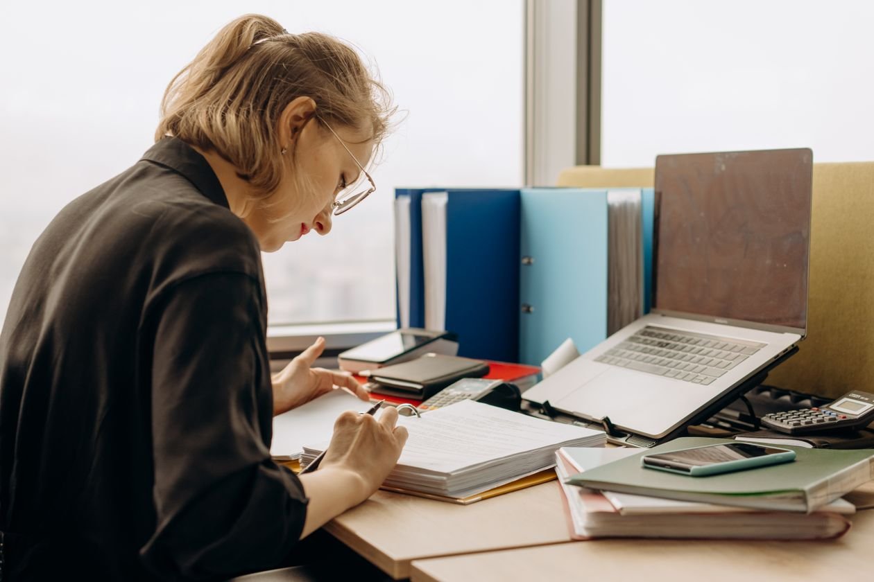 Business owner buried in accounting paperwork — the sign you've outgrown QuickBooks