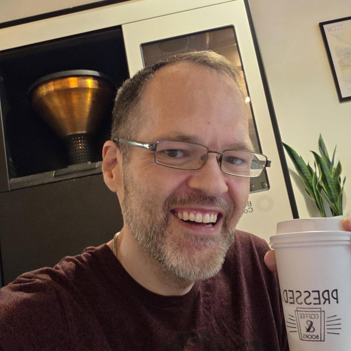 David Strausser smiling with a coffee cup