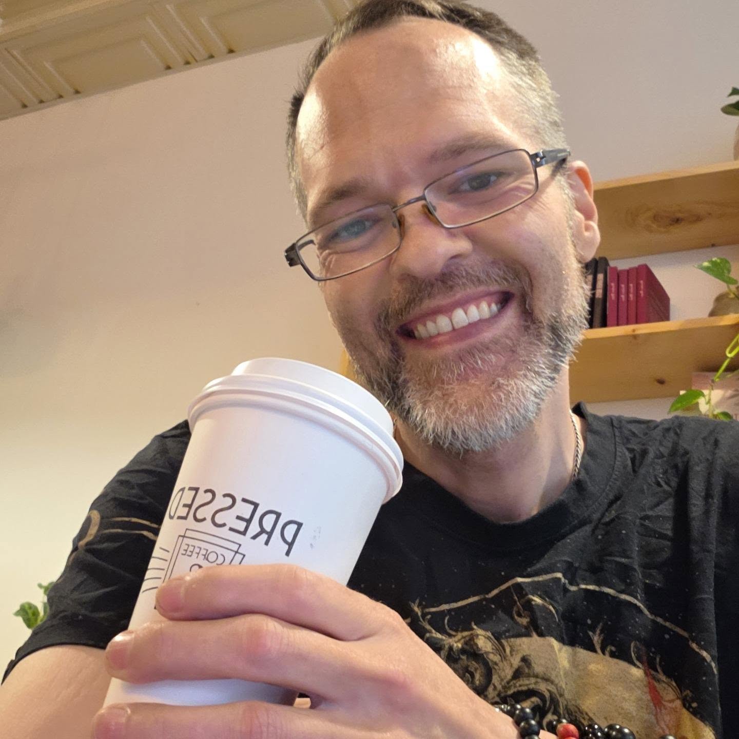 David Strausser smiling with a coffee cup