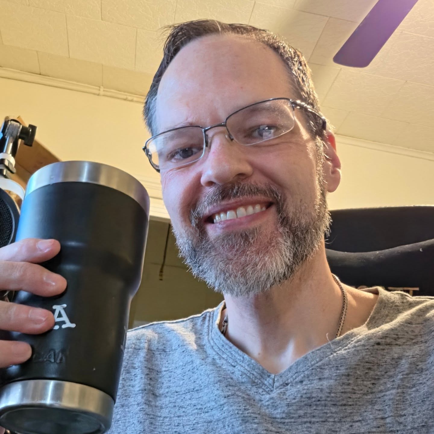 David Strausser at his desk with a travel tumbler